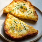 Crispy egg and cheese toasts topped with herbs and served on a plate.