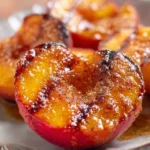 Grilled peaches with cinnamon and brown sugar served on a plate