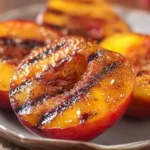 Delicious grilled peaches topped with cinnamon and brown sugar on a serving plate
