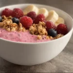 High protein breakfast smoothie bowl topped with fruits and seeds