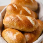 Freshly baked homemade hoagie rolls on a wooden board