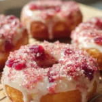 Paleo Rhubarb Doughnuts topped with fresh rhubarb and a dusting of coconut flour.